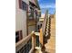 Charming cottage exterior featuring a wooden staircase leading to a deck with metal and wood railing at 2997 Happy Hollow Se Dr, Conyers, GA 30094