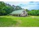 Spacious home exterior with green roof, side deck, and surrounded by lush greenery at 2997 Happy Hollow Se Dr, Conyers, GA 30094
