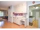 Kitchen with white cabinetry, red tile backsplash, and an adjacent seating area at 2997 Happy Hollow Se Dr, Conyers, GA 30094
