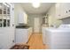 Well-lit laundry room with abundant storage, white cabinetry, and modern washer and dryer at 2997 Happy Hollow Se Dr, Conyers, GA 30094