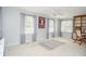 This living room features carpeted floors, multiple windows, a ceiling fan, and built-in shelving at 2997 Happy Hollow Se Dr, Conyers, GA 30094