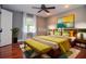 This main bedroom features a queen bed, ceiling fan, bedside tables, and colorful decor at 2997 Happy Hollow Se Dr, Conyers, GA 30094