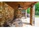Covered stone patio with ceiling fan and stone flooring for comfortable outdoor living at 2997 Happy Hollow Se Dr, Conyers, GA 30094
