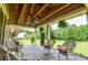 Spacious covered porch with stone flooring, comfortable seating, and a peaceful outdoor setting at 2997 Happy Hollow Se Dr, Conyers, GA 30094