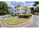 Exterior view of a white condo building with well-maintained green lawn and landscaping at 403 Abingdon Way, Atlanta, GA 30328