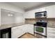 Modern kitchen features stainless steel appliances, light countertops, and a view into the dining area at 403 Abingdon Way, Atlanta, GA 30328