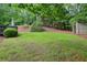 Wide shot of the backyard with a wooded fence line, a shed, and a seating area at 503 Kensington Estates Trce, Woodstock, GA 30188