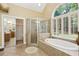 Large primary bathroom featuring a soaking tub, glass shower, and access to the closet and vanity area at 503 Kensington Estates Trce, Woodstock, GA 30188