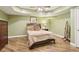 Well-lit bedroom with hardwood floors, neutral walls, a ceiling fan, and a comfortable queen bed at 503 Kensington Estates Trce, Woodstock, GA 30188