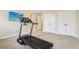 Well-lit exercise room with a treadmill and a wall-mounted television at 503 Kensington Estates Trce, Woodstock, GA 30188