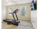 Bright exercise room with a treadmill, a ceiling fan, and a wall-mounted TV for entertainment at 503 Kensington Estates Trce, Woodstock, GA 30188