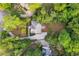 Aerial view showcases a home nestled amongst lush trees with a stone-paved driveway and a secluded backyard at 2655 Boulder Creek Ne Dr, Roswell, GA 30075