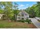 A two-story home sits surrounded by lush trees, grass and professional landscaping at 2655 Boulder Creek Ne Dr, Roswell, GA 30075