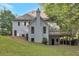 Exterior view of the home featuring a lush lawn, rear entry garage, and elevated deck at 2655 Boulder Creek Ne Dr, Roswell, GA 30075