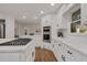 Modern kitchen with stainless steel appliances, a cooktop island, white cabinets, and hardwood flooring at 2655 Boulder Creek Ne Dr, Roswell, GA 30075