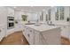 Open kitchen featuring a large central island with cooktop, white cabinets, and stainless steel appliances at 2655 Boulder Creek Ne Dr, Roswell, GA 30075
