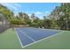 An immaculately maintained tennis court with green and blue surfaces, benches for spectators, and high net at 2655 Boulder Creek Ne Dr, Roswell, GA 30075