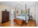 Cozy bedroom featuring a four-poster bed, wood floors, and neutral walls at 3792 Harts Mill Ne Ln, Brookhaven, GA 30319