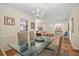 Elegant dining room showcasing a glass-top table, chandelier, and seamless flow to the living area at 3792 Harts Mill Ne Ln, Brookhaven, GA 30319