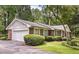 Charming brick home with a two-car garage, beautiful landscaping, and lovely light-blue shutters at 3792 Harts Mill Ne Ln, Brookhaven, GA 30319