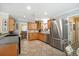 Bright kitchen boasts stainless steel appliances, tile floors, and wood cabinets with ample counter space at 3792 Harts Mill Ne Ln, Brookhaven, GA 30319