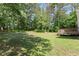 Lush backyard with mature trees, providing shade and privacy to enjoy the outdoors at 5150 Shadow Path Sw Ln, Lilburn, GA 30047