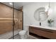 Modern bathroom featuring a glass-enclosed shower and floating vanity with stylish fixtures and lighting at 5150 Shadow Path Sw Ln, Lilburn, GA 30047