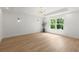 Light-filled bedroom with hardwood floors, recessed lighting, chandelier, and a view of trees outside the window at 5150 Shadow Path Sw Ln, Lilburn, GA 30047