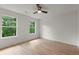 Bright, airy bedroom with hardwood floors and two large windows overlooking lush greenery at 5150 Shadow Path Sw Ln, Lilburn, GA 30047
