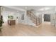 Bright entryway with light wood floors, modern staircase, and kitchen island view at 5150 Shadow Path Sw Ln, Lilburn, GA 30047