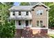 Beautiful two-story home with a brick foundation, charming front porch, and manicured landscaping at 5150 Shadow Path Sw Ln, Lilburn, GA 30047