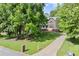 Two-story home featuring a long driveway, well-maintained lawn, and mature trees at 5150 Shadow Path Sw Ln, Lilburn, GA 30047