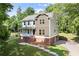 Charming two-story home with a brick foundation, front porch, and lush green lawn at 5150 Shadow Path Sw Ln, Lilburn, GA 30047