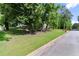 Serene, landscaped property showcasing a well-maintained lawn and mature trees enhancing curb appeal at 5150 Shadow Path Sw Ln, Lilburn, GA 30047