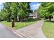 Picturesque home nestled on a lush green lot with mature trees and a long driveway at 5150 Shadow Path Sw Ln, Lilburn, GA 30047