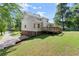 Back exterior featuring a wooden deck, a large yard, and a two-car garage at 5150 Shadow Path Sw Ln, Lilburn, GA 30047