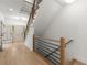 Bright foyer with light wood floors, modern staircase with black metal railing, and a white front door at 5150 Shadow Path Sw Ln, Lilburn, GA 30047