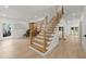 Bright foyer featuring hardwood floors, modern staircase with black railings, and an abundance of natural light at 5150 Shadow Path Sw Ln, Lilburn, GA 30047