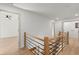 Second-floor hallway with wood floors and metal and wood railing at 5150 Shadow Path Sw Ln, Lilburn, GA 30047