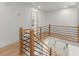 Upstairs hallway with wood floors, a modern railing, and a view of the foyer below at 5150 Shadow Path Sw Ln, Lilburn, GA 30047
