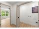 Hallway next to a laundry room with a utility sink, closet, and a view of a window with trees at 5150 Shadow Path Sw Ln, Lilburn, GA 30047