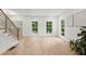 Living room with white walls, light wood flooring, and windows with green views at 5150 Shadow Path Sw Ln, Lilburn, GA 30047