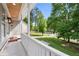 Inviting porch view featuring a manicured lawn, lush trees, and a serene neighborhood at 5150 Shadow Path Sw Ln, Lilburn, GA 30047