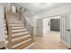 Staircase with light wood treads and modern black metal railings leads to an open floorplan at 5150 Shadow Path Sw Ln, Lilburn, GA 30047