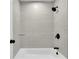 Bathroom tub and shower with light-colored tile and black shower head and fixtures at 683 Highland Ct, Marietta, GA 30068