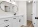 Modern bathroom features white cabinetry, a sleek oval mirror, and updated fixtures and finishes at 683 Highland Ct, Marietta, GA 30068