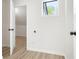 Neutral laundry room with sleek hardwood flooring, white walls, and natural light from small window at 683 Highland Ct, Marietta, GA 30068