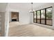 Well-lit living room with stone fireplace, modern chandelier and oversized grid window showcasing exterior views at 683 Highland Ct, Marietta, GA 30068