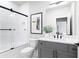 Modern bathroom with a sleek glass shower door, framed art, and elegant vanity with black hardware at 7130 Summit Pl, Alpharetta, GA 30009