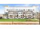 Modern townhome complex boasts a manicured lawn and elegant brick and white facade at 7130 Summit Pl, Alpharetta, GA 30009